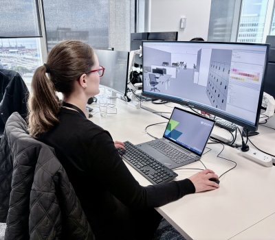 A designer sitting at an office desk and computer.